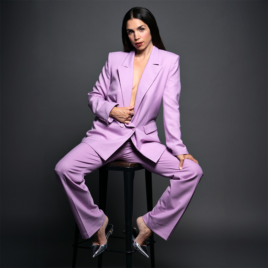Elena Furiase posando sentada con traje y zapatos de Maje y anillo de Luxenter